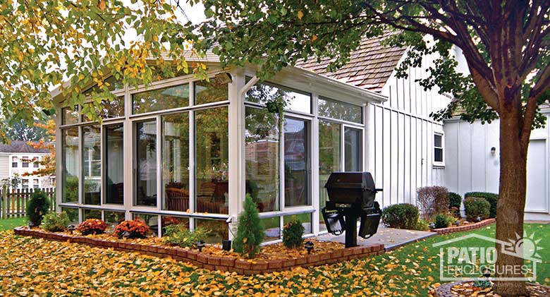 White four season sunroom with aluminum frame, glass knee wall, transom and gable roof.