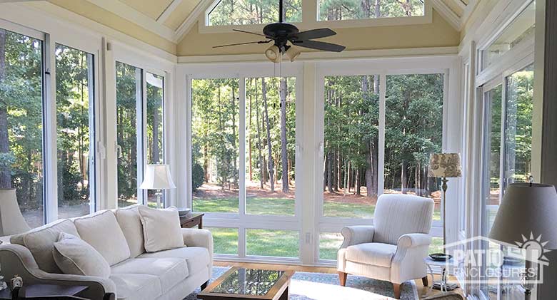 White four season sunroom with vinyl frame and glass knee wall enclosing an existing screened-in porch