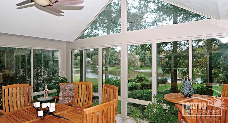White all season sunroom with aluminum frame, glass knee wall and gable roof.