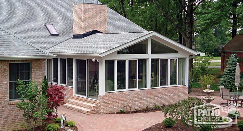 White all season sunroom with aluminum frame and gable roof.