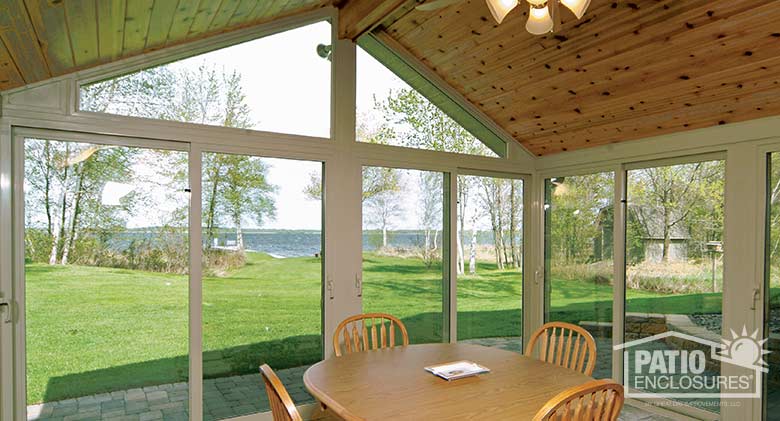 Sandstone all season sunroom with vinyl frame and custom wood gable roof.