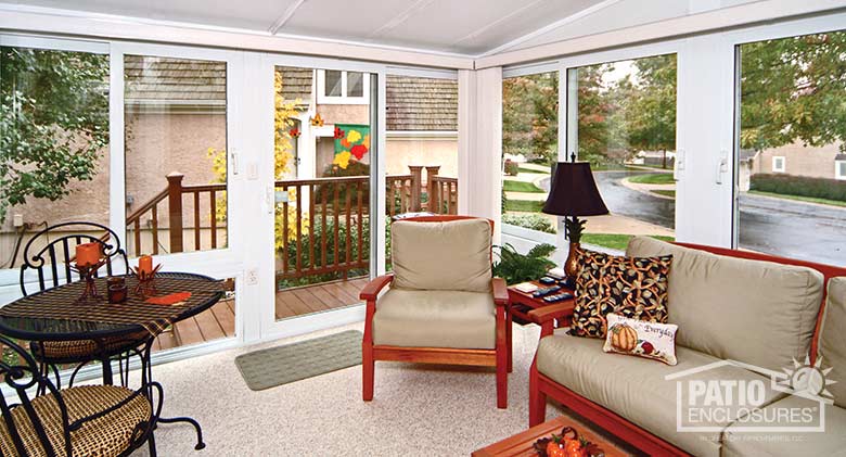 White all season sunroom with vinyl frame and single-slope roof.