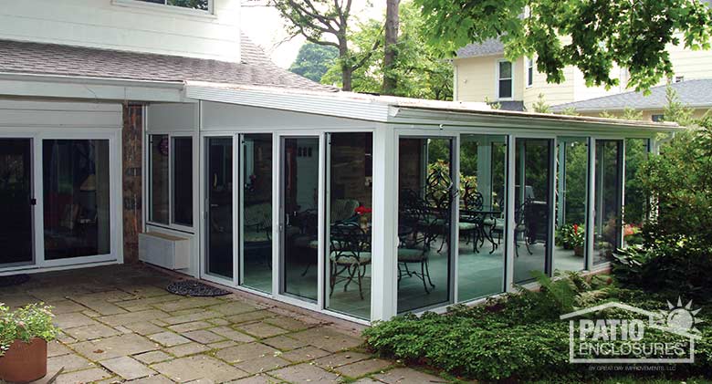 White all season sunroom with aluminum frame and single-slope roof.