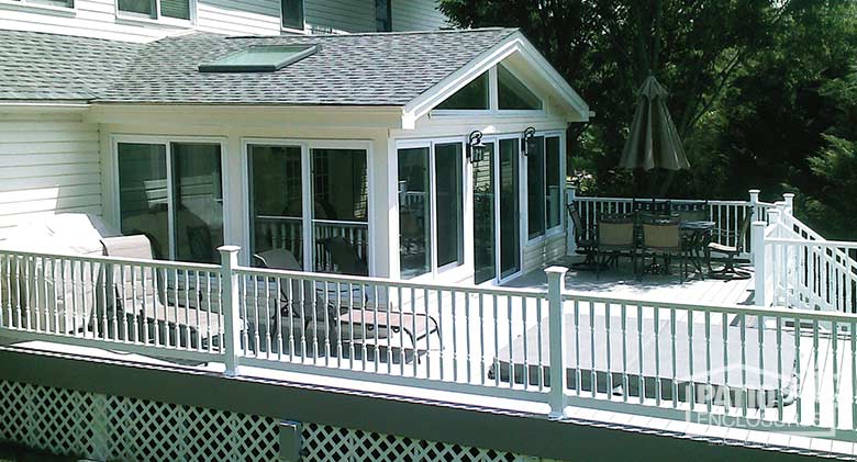White all season sunroom with vinyl frame, solid knee wall and gable roof with skylight.