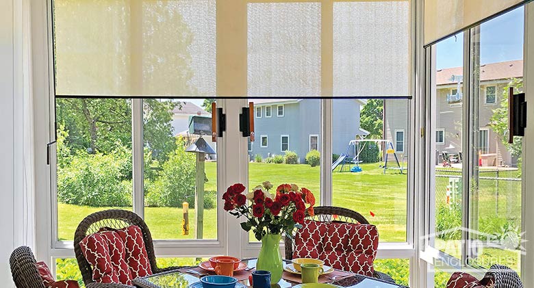 Ivory roller shades complement a contemporary dining table.