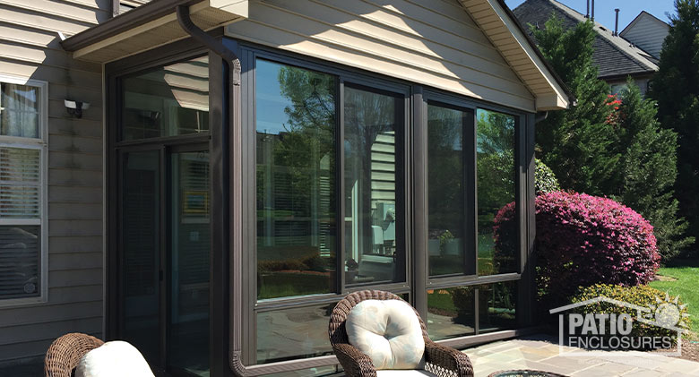 Bronze four season sunroom with aluminum frame enclosing an existing covered patio.