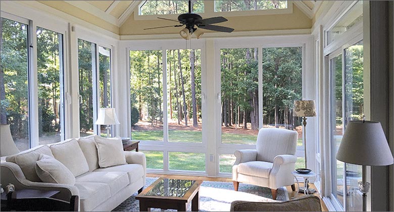 Four season aluminum sunroom in sandstone with shingled single-slope roof and solid knee wall