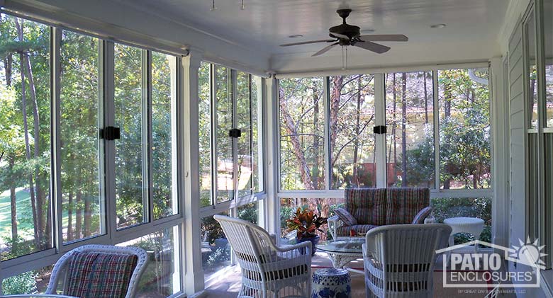 White three season sunroom enclosing an existing covered porch.