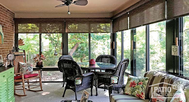 Three season room with insulated glass and roller shades enclosing an existing covered porch.