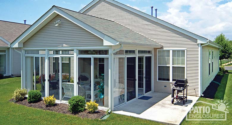 White three season sunroom with transoms enclosing an existing covered patio.