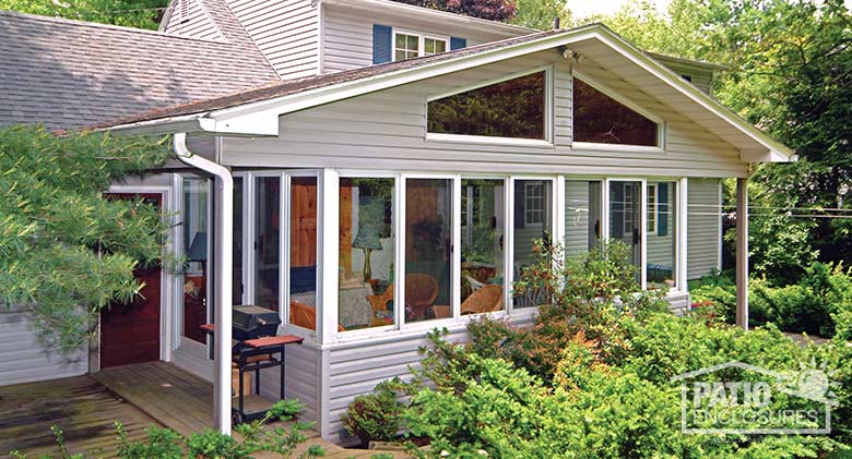 Traditional sunroom with white aluminum frame, solid knee wall and gable roof.
