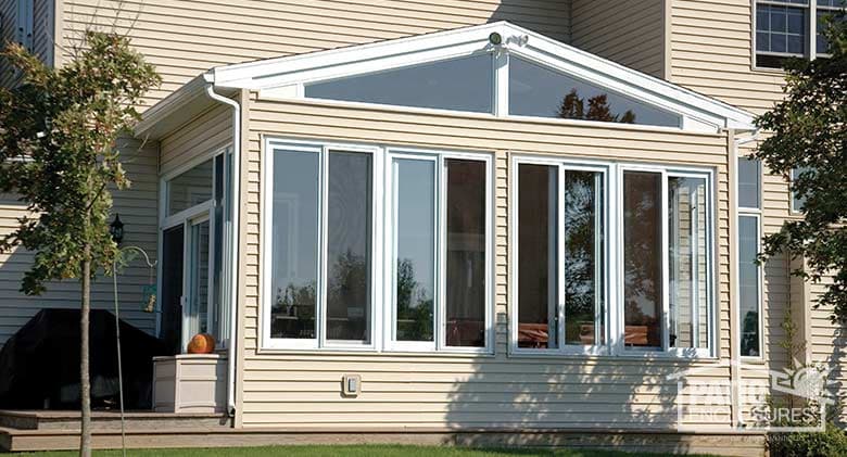 Traditional sunroom with white vinyl frame, glass knee wall and gable roof.