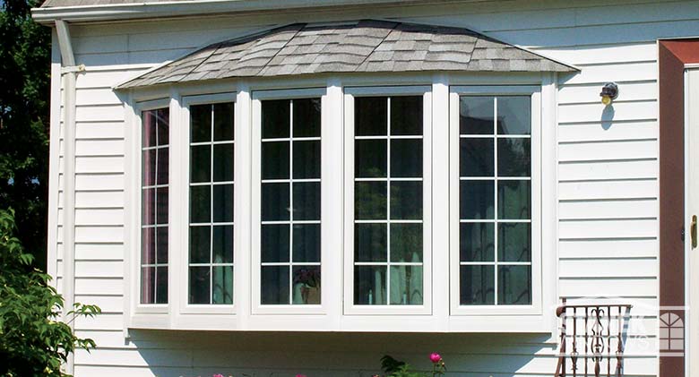 Five-lite bow window with interior colonial grids and shingled hip roof.