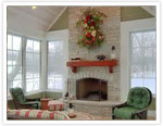 Stunning stone fireplace with mantle in a beautiful sunroom
