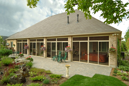 Outside View of a Very Large Sunroom Under Existing Roof As Part of a Patio