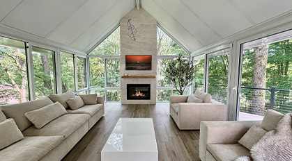 Grand Prize winner 2026 : Two interior & one exterior photo of a four-season room with fireplace, comfortable seating, gable roof.