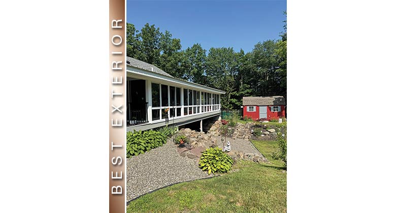 Best Exterior: Long white porch enclosure spanning a culvert with curved hosta flower beds in front.
