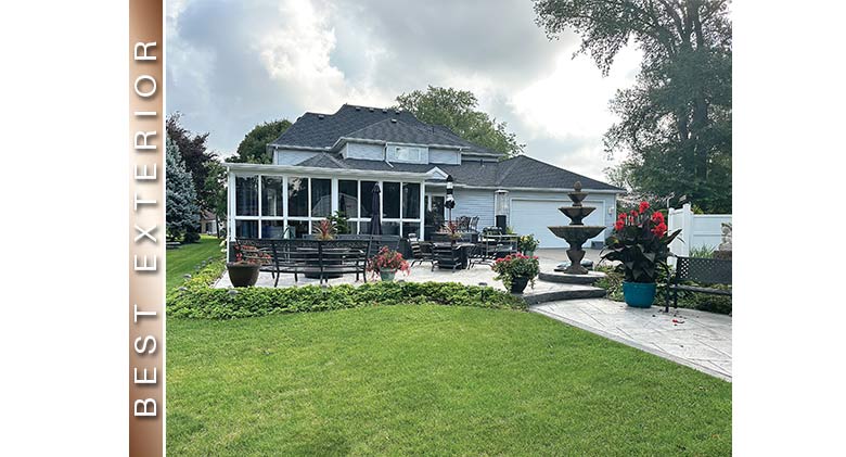 Best Exterior: Three-season room on light gray home. Large patio with furniture, fountain, potted plants in front.
