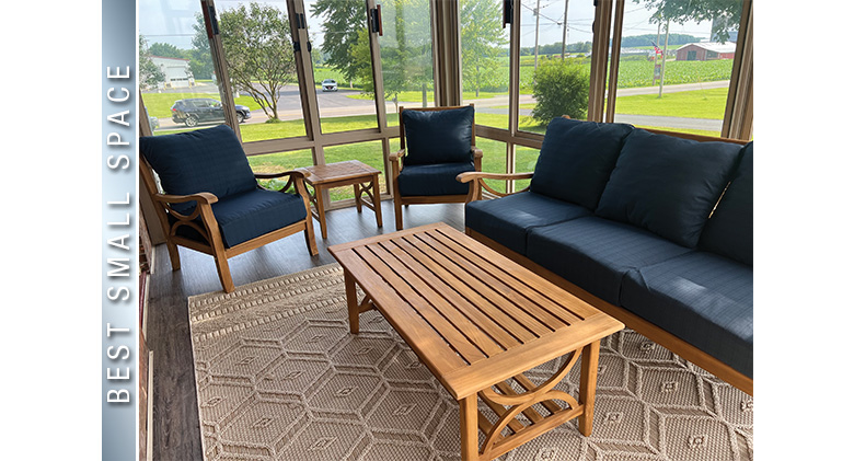 Best Small Space: Interior of a three-season patio enclosure with sandstone frame, dark blue sofa & chairs, coffee table.

