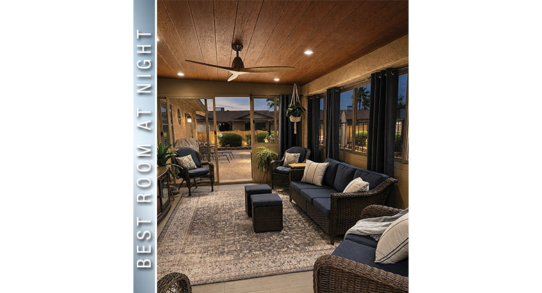 Best at Night: Three-season patio enclosure in the evening with indoor and outdoor lighting, wicker furniture, blue
cushions.
