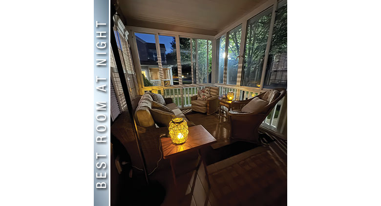 Best at Night: Interior of a three-season patio enclosure with comfortable seating lit by candles at night.

