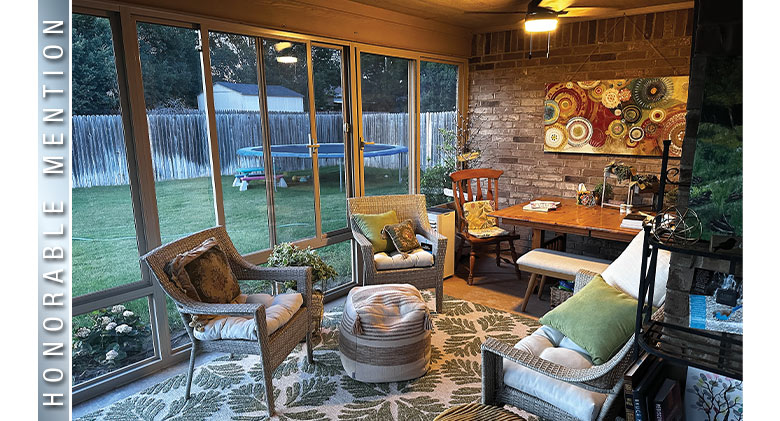 Honorable Mention: Evening in a three-season room with brick wall, seating area, table and chairs.
