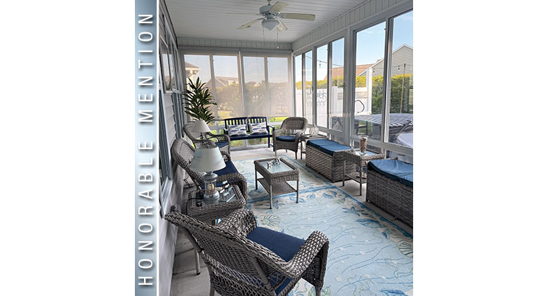 Honorable Mention: Interior of a three-season patio enclosure with brown wicker furniture and blue cushions.

