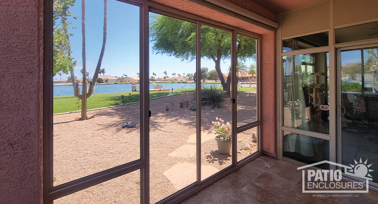 Screened patio enclosure in a pink stucco one-story home in Arizona, potted tulips in front and outdoor kitchen on the side