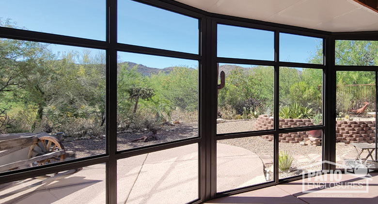 
 Three-quarter view of a brown screen room with picket railing along the front. Sliding screen doors are on the left. 