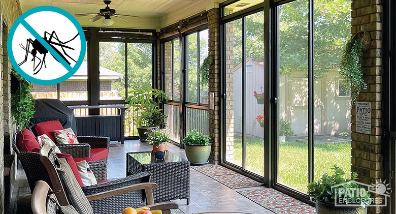 Interior of a screened-in porch with integrated picket railing and furnished with brown wicker furniture with red cushions.