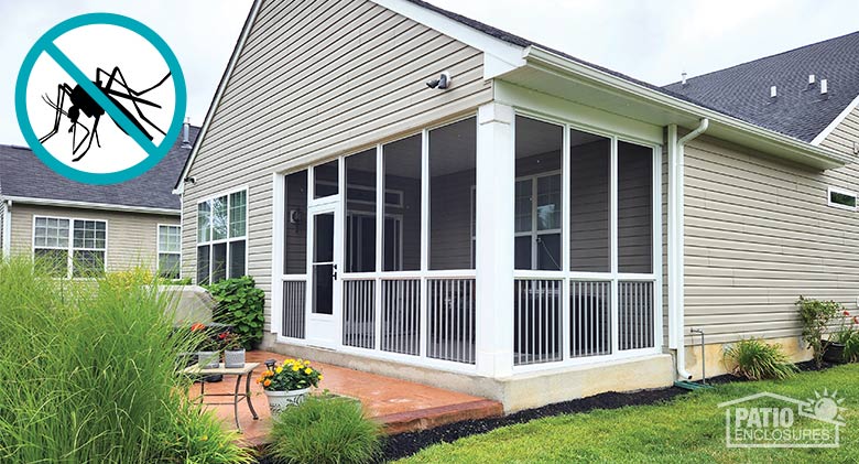 A tan home with a corner patio enclosed with a screen room with picket railing, additional terra cotta patio area in front.