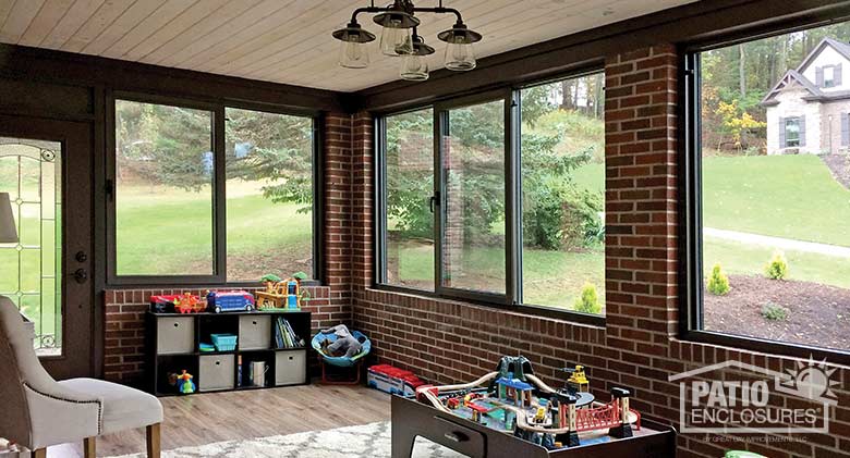 Interior of bronze four season sunroom with aluminum frame enclosing an existing over-the-garage porch.