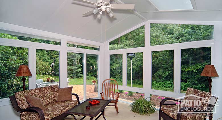 White four season sunroom with vinyl frame, glass knee wall and gable roof with glass roof panels.