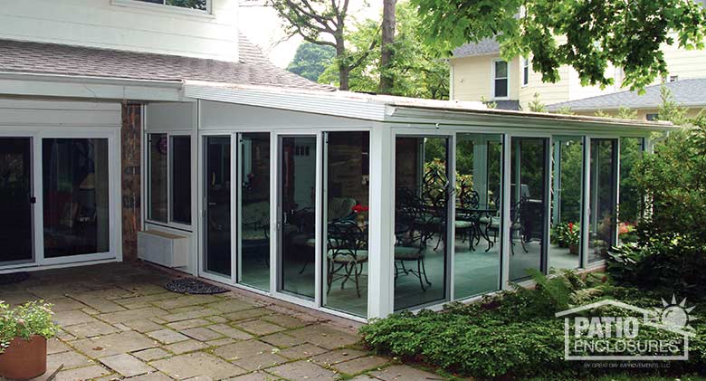 White four season sunroom with aluminum frame and single-slope roof.