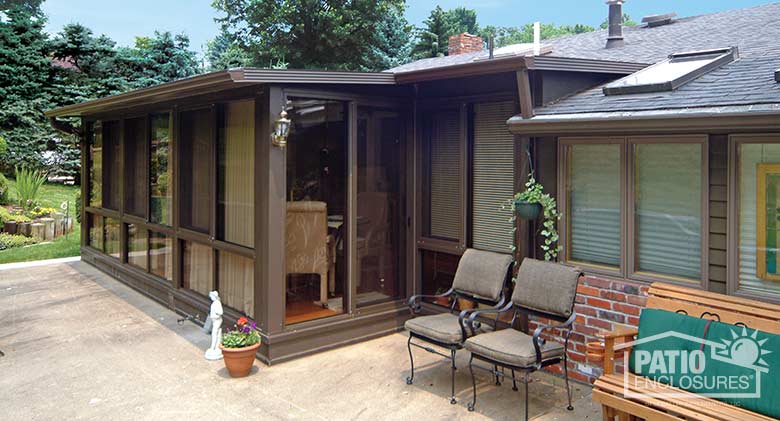 Bronze four season sunroom with aluminum frame, glass knee wall and single-slope roof.