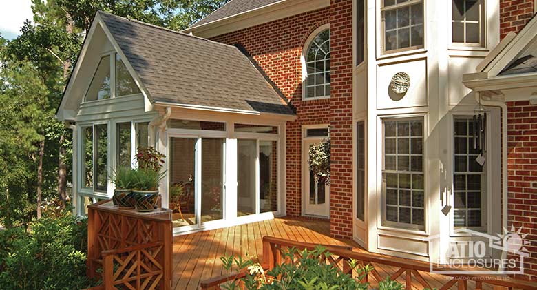 White four season sunroom with vinyl frame, glass knee wall and gable roof.