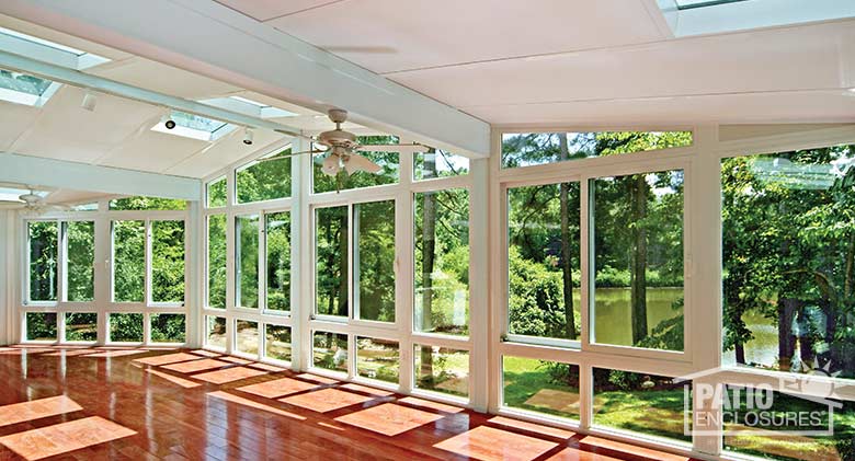 Interior of white all season sunroom with vinyl frame and gable roof.