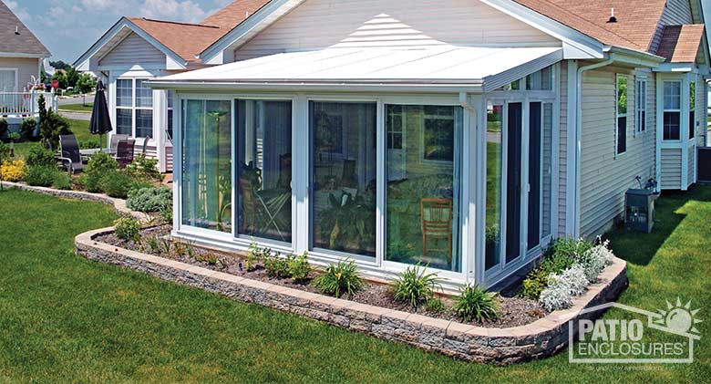 White all season sunroom with vinyl frame and single-slope roof.