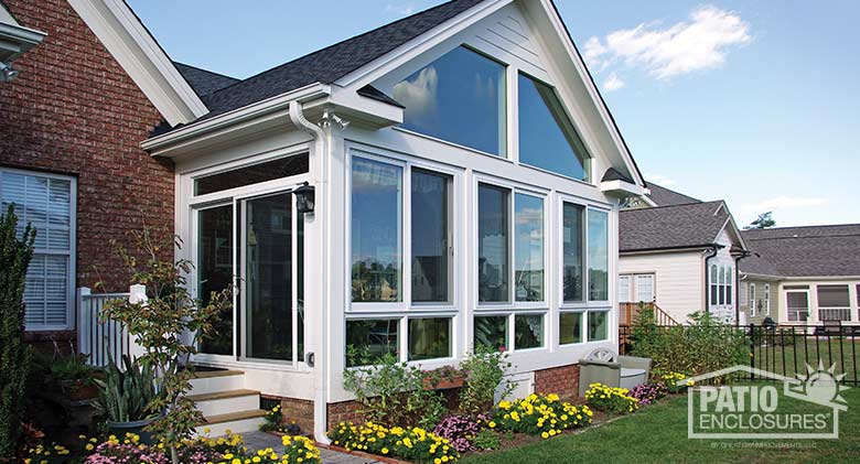 White all season sunroom with vinyl frame, glass knee wall and gable roof.
