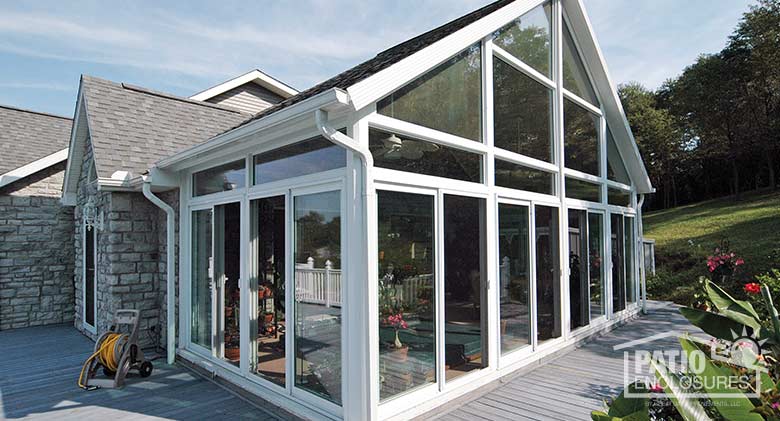 White all season sunroom with vinyl frame, transom and gable roof.