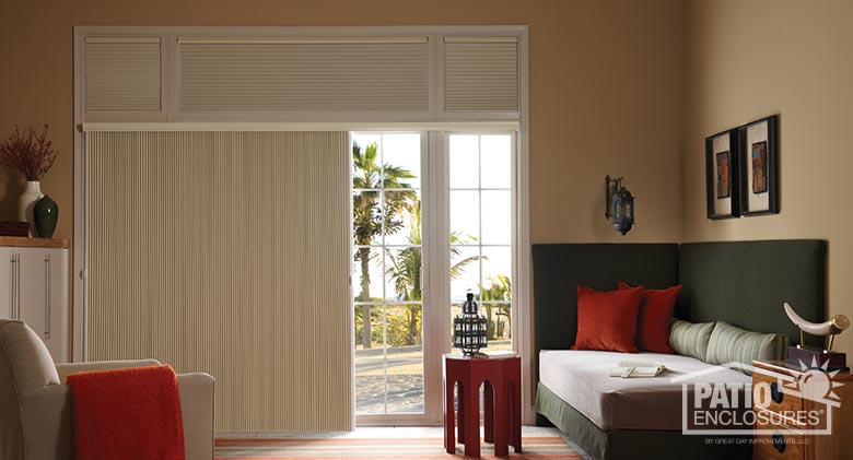 Single-cell motorized cellular shades in honey on top and SlideVue cellular shade on patio door.