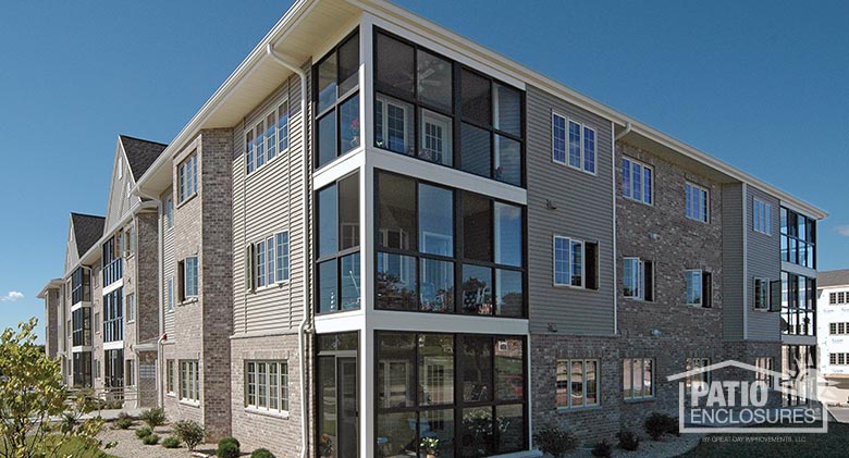 Three season rooms in bronze enclosing existing covered porches at Grafton Square Condominiums, Grafton, WI.