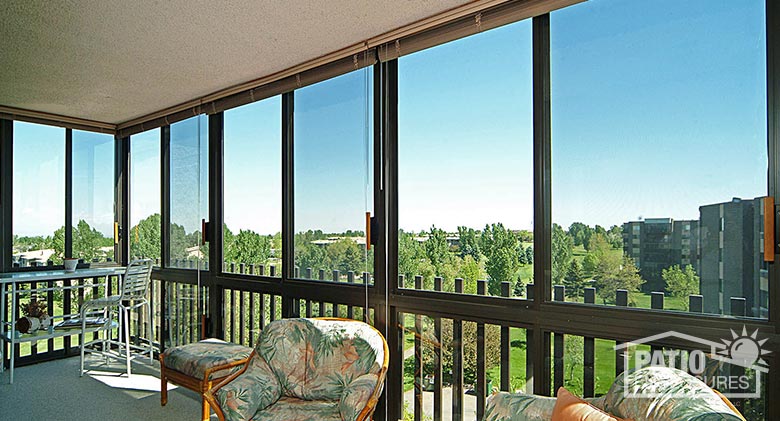 Interior of screen room in bronze with picket railing system enclosing existing covered balconies at multi-story condominium.