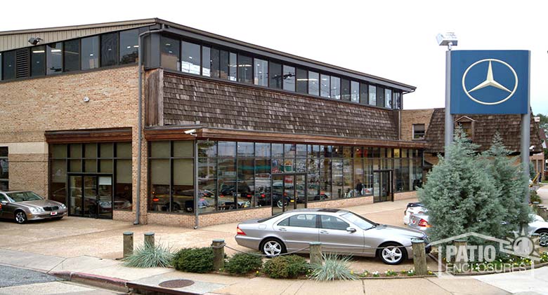 Glass enclosure under an existing roof with a bronze, aluminum frame.