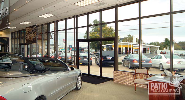 Interior of glass enclosure under an existing roof with a bronze, aluminum frame.