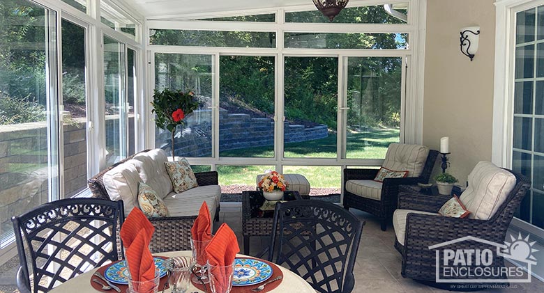 interior of a white sunroom with a dining table in foreground and comfortable seating area in the background