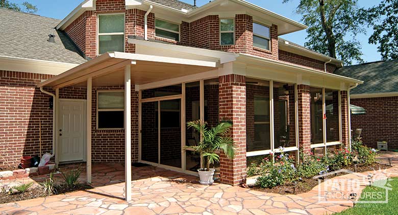 Elite three season room in sandstone with glass knee wall enclosing an existing covered patio.