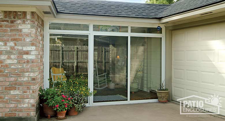 Elite three season room in white with transom enclosing an existing breezeway.