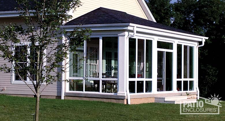 Elite three season room in white with insulated glass enclosing an existing covered back porch.