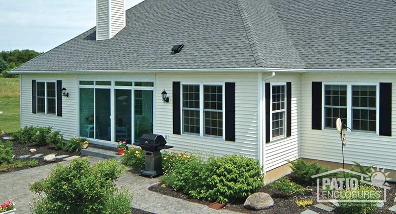 Four season room in white with vinyl frame and transom enclosing an existing back porch